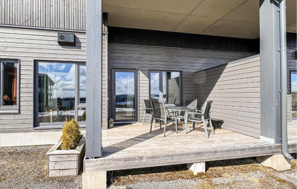 a wooden deck with a table and chairs on it at 2 Bedroom Awesome Apartment In Sjusjøen in Sjusjøen