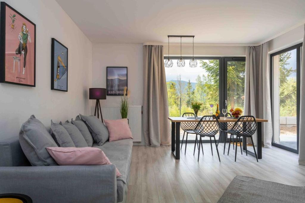 a living room with a couch and a dining room table at Daj Sobie Spokój - WIDOK 800mnpm OGRÓDEK in Szklarska Poręba