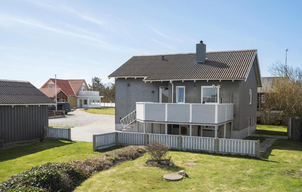 a house with a balcony in a yard at 2 Bedroom Amazing Home In Ringkøbing in Ringkøbing