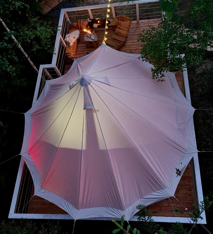 a large umbrella sitting on top of a porch at Glamping Štôla Brezovy vanok in Vyšné Hágy