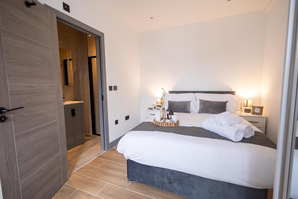 a bedroom with a large white bed with towels on it at New London 2 Bedroom, 2 Bathroom Flat in Finchley