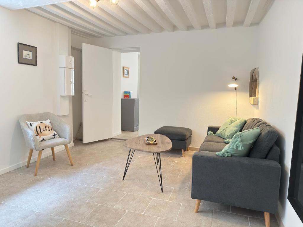 un salon avec un canapé et une table dans l'établissement Le Clos Guillaume, à Bayeux