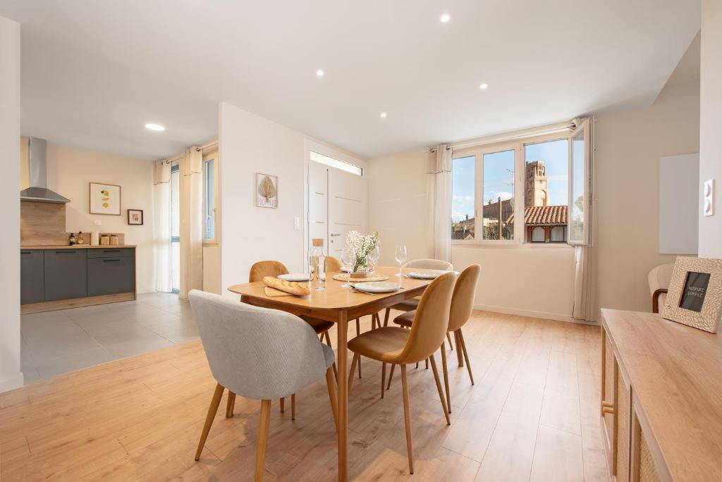 une cuisine et une salle à manger avec une table et des chaises dans l'établissement La passerelle - vue et proximité cathédrale, terrasse, parking privé, à Albi