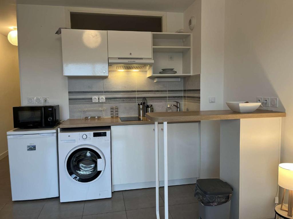 une cuisine avec un lave-linge et un lave-linge dans l'établissement Appartement 2 pièces LR340-D101, à La Rochelle