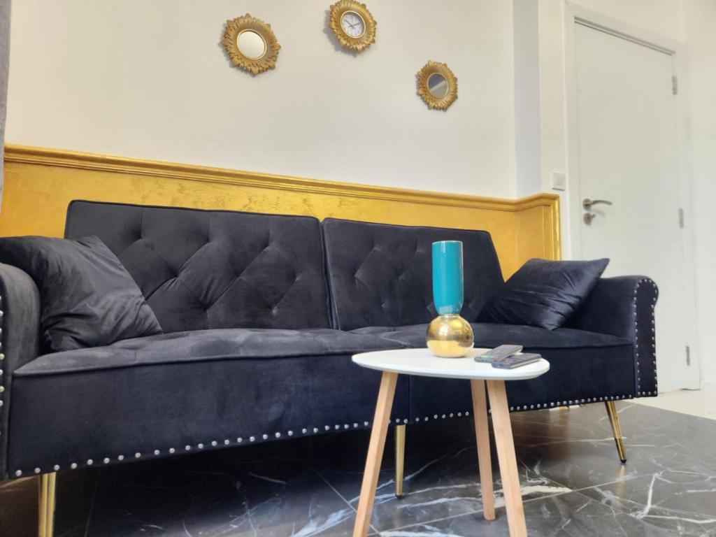 a black couch sitting in a living room with a table at luxury Apartament TD one bedroom in Sofia