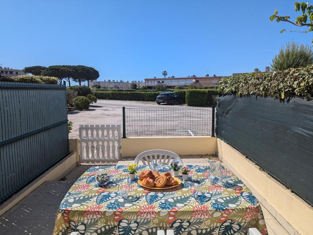 - une table avec une assiette de nourriture sur la terrasse dans l'établissement Sol-y-Days Canastel RDC avec parking, au Grau-du-Roi