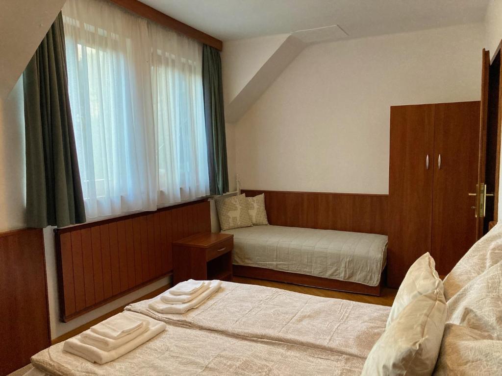 pokój hotelowy z dwoma łóżkami i oknem w obiekcie Pénzpataki Vadászház w mieście Répáshuta