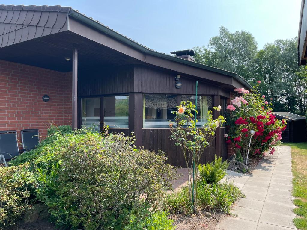 a house with flowers on the side of it at Fichtenhain - Lastering Ferienhäuser & Apartments in Wettringen