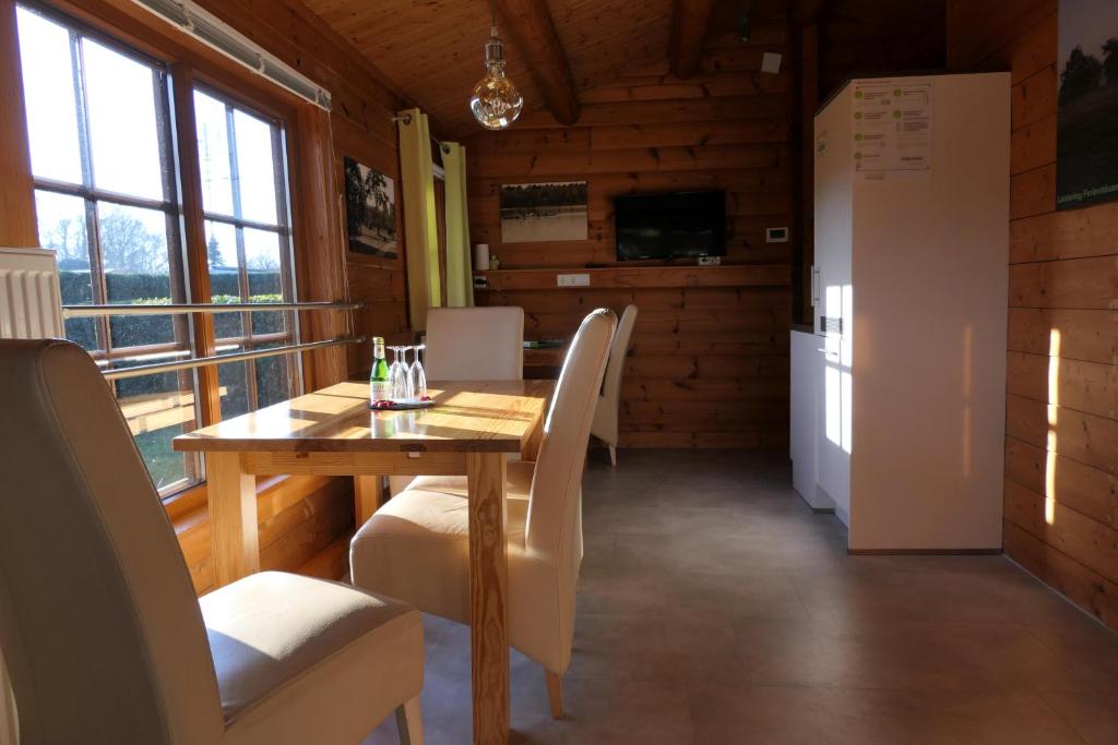 a dining room with a table and chairs and a refrigerator at Marlies - Lastering Ferienhäuser & Apartments in Wettringen