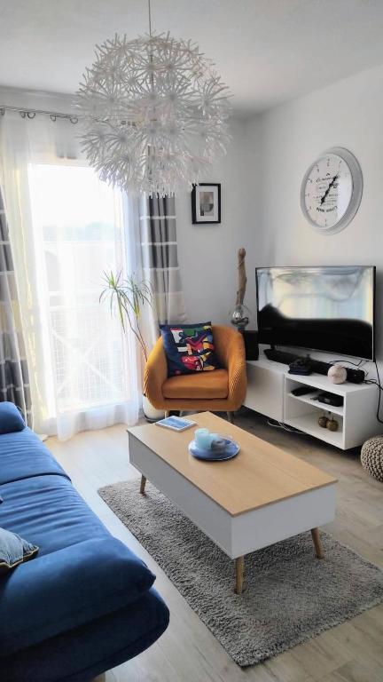 un salon avec un canapé bleu et une télévision dans l'établissement Appartement très calme Aix en Provence, à Aix-en-Provence