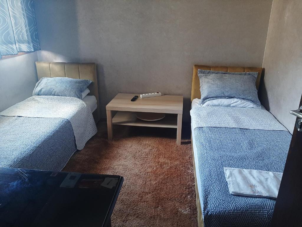 a small room with two beds and a table at Chambre d'hôte jardins de Hamria in Meknès