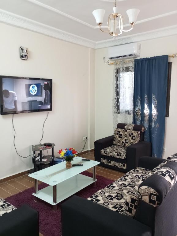 a living room with two couches and a tv at Golfe de Makepe in Douala