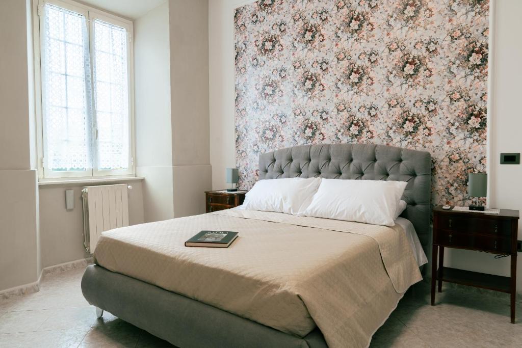a bedroom with a large bed with a floral wallpaper at Le Case delle Rose in Civitavecchia