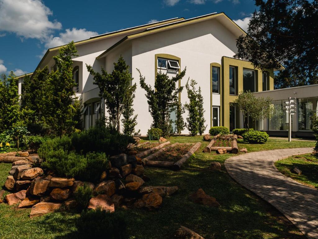 a house with a garden in front of it at Kurotel Centro Contemporâneo de Saúde e Bem Estar in Gramado