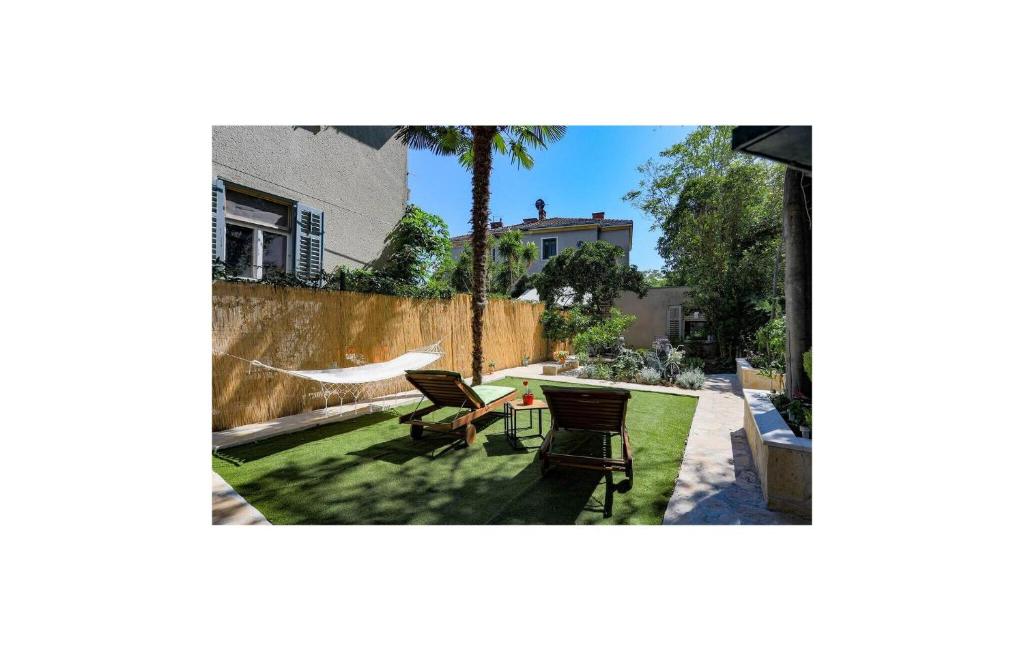 a patio with chairs and a hammock in a yard at Awesome Home In Split in Split