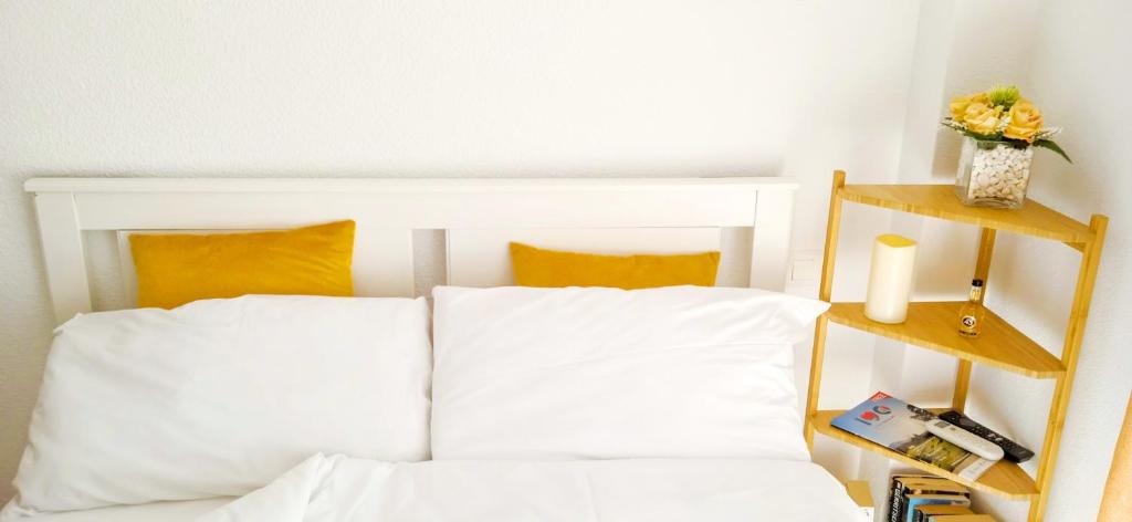 a bedroom with a white bed with two wooden shelves at The Seven Seas in Benalmádena