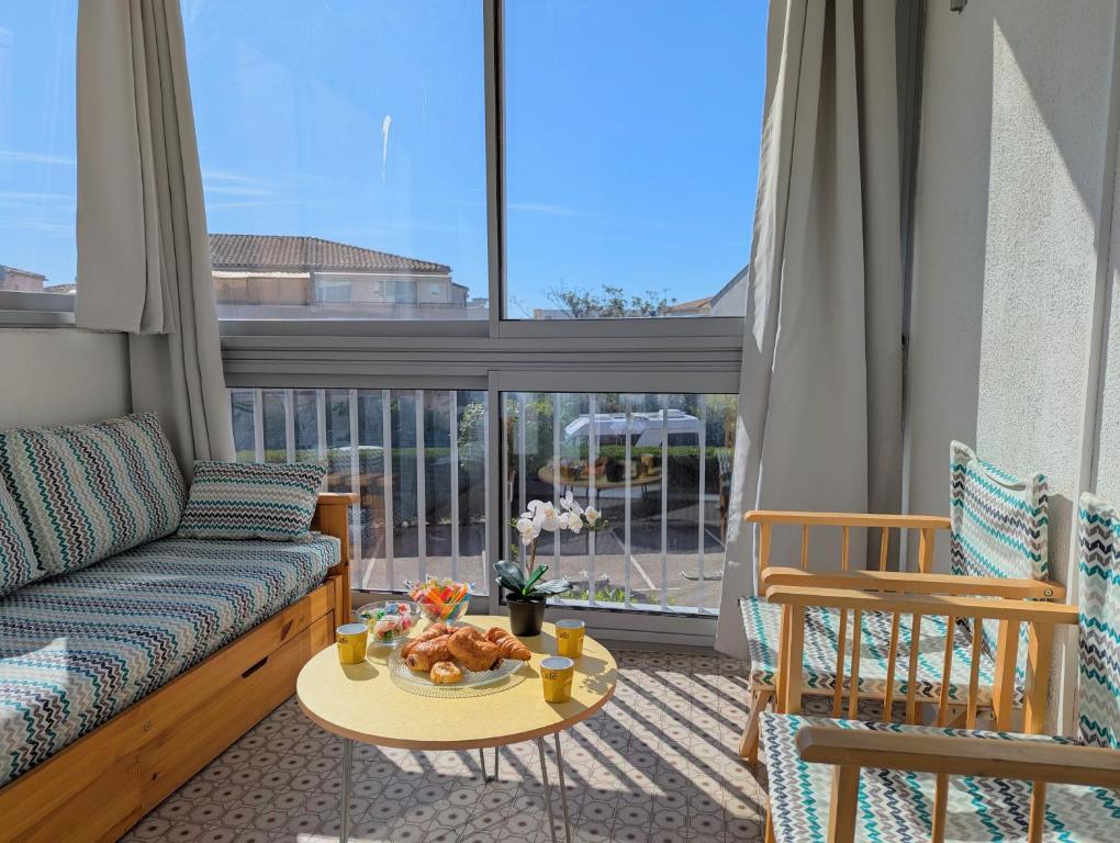 un salon avec un canapé et une table dans l'établissement Sol-y-Days Drakkar, Studio fonctionnel proche centre-ville et plages, au Grau-du-Roi