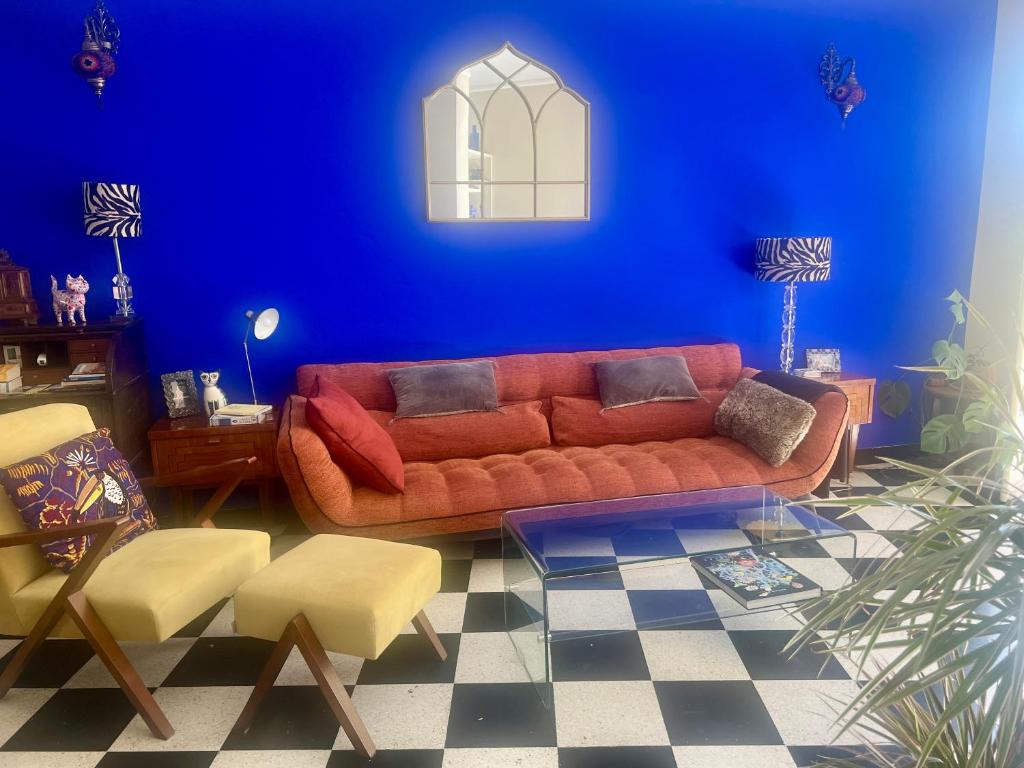 - un salon avec un canapé rouge et un mur bleu dans l'établissement Le Palais Antibois, à Antibes