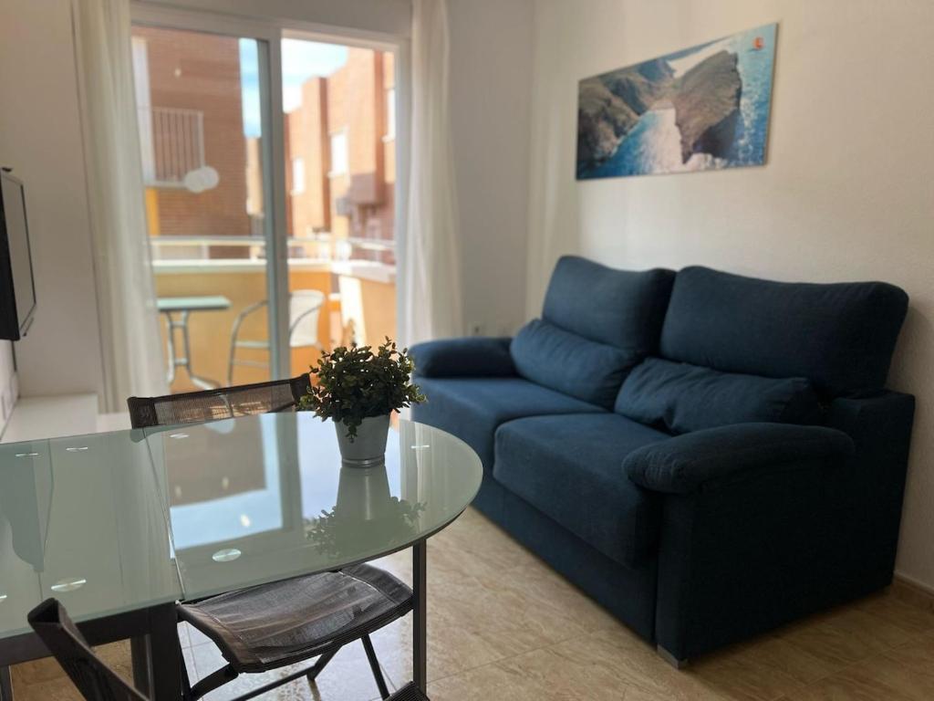 a living room with a blue couch and a glass table at Isla Plana Paradise in Cartagena