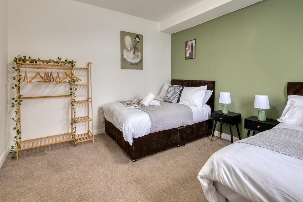 a bedroom with two beds and a mirror at Comfortable 3 Bedroom Home with Parking Pet Friendly Sleeps 8 in Knowsthorpe