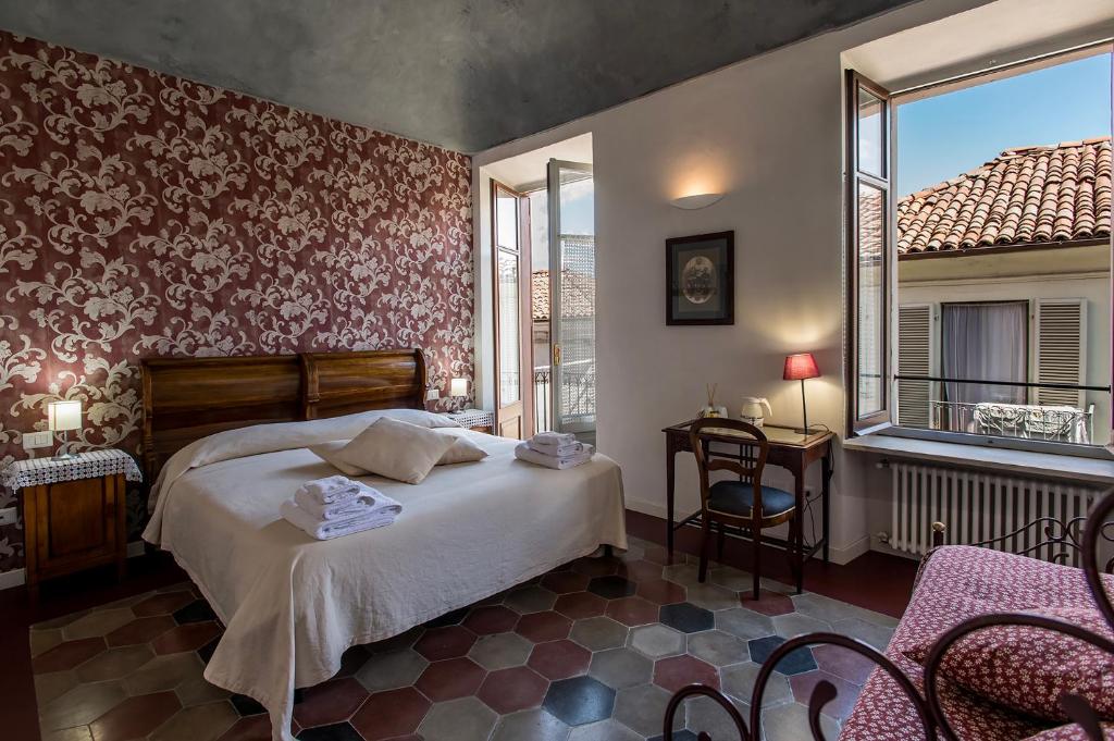 a bedroom with a bed and a table and chairs at L' estate di san Martino - free park in Asti