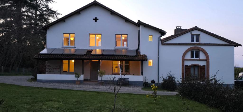 une grande maison blanche avec ses lumières allumées dans l'établissement Country House, à Lafrançaise