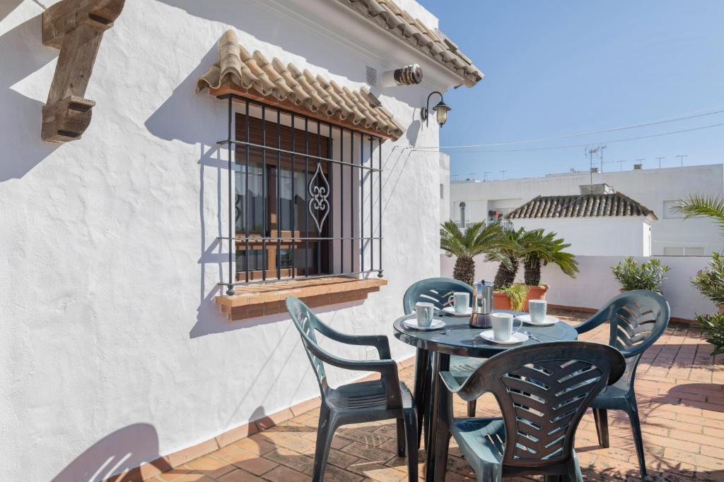 a patio with a table and chairs and a window at Preciosa casa en Conil in Conil de la Frontera