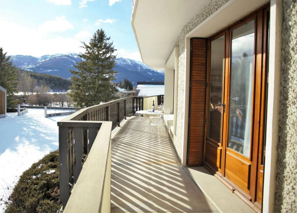 une passerelle en bois menant à un balcon avec des montagnes dans l'établissement Plein-Sud - Parking & Vue Montagnes, à Barcelonnette