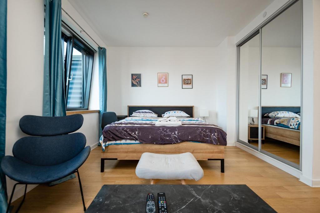 a bedroom with a bed and a chair at Apartment Atrium- A blok in Novi Beograd