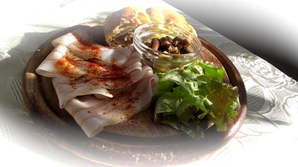 un piatto di cibo con carne e insalata su un tavolo di Maso La Vecchia Quercia a Baselga di Pinè