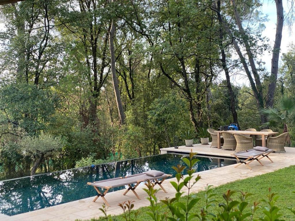 une piscine avec deux tables et deux chaises à côté d'une piscine dans l'établissement Belle maison atypique, à Roquefort-les-Pins