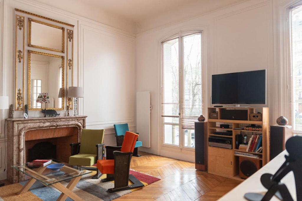 un salon avec une cheminée et une télévision dans l'établissement Spacious nest with terrace near Batignolles, à Paris