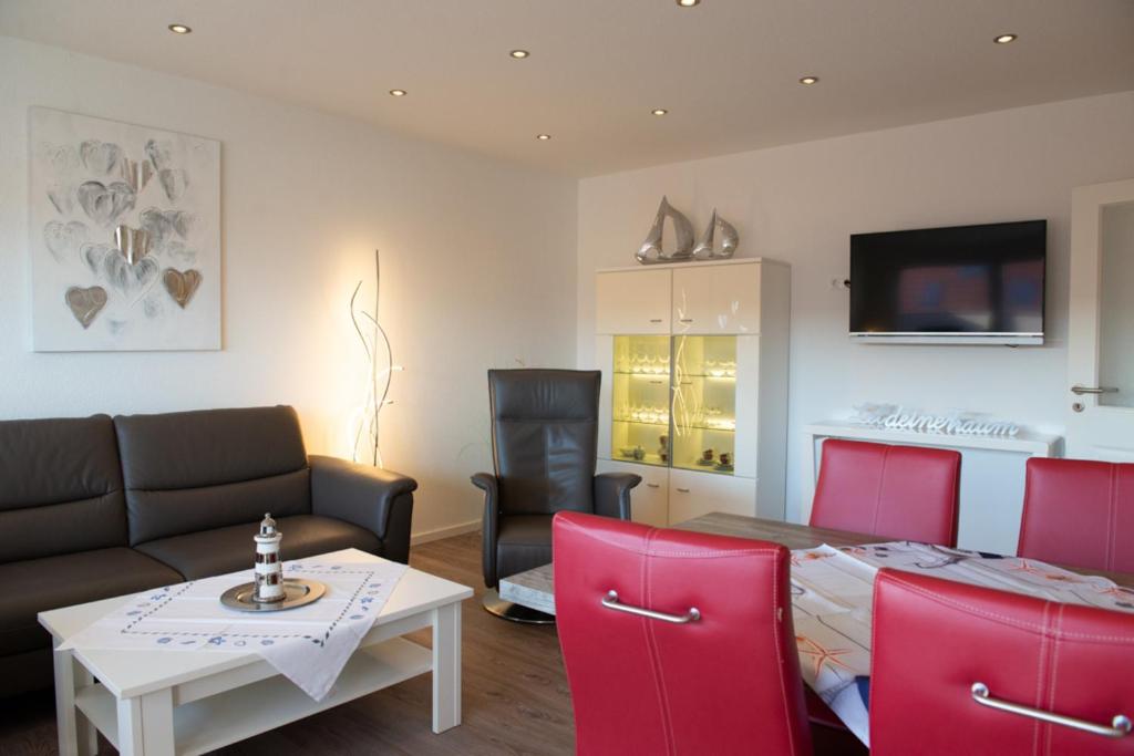 a living room with a couch and a table and chairs at Santa Maria in Norddeich