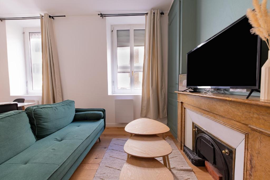 un salon avec un canapé et une télévision à écran plat dans l'établissement Le Palais Boursier - Cordeliers, à Lyon