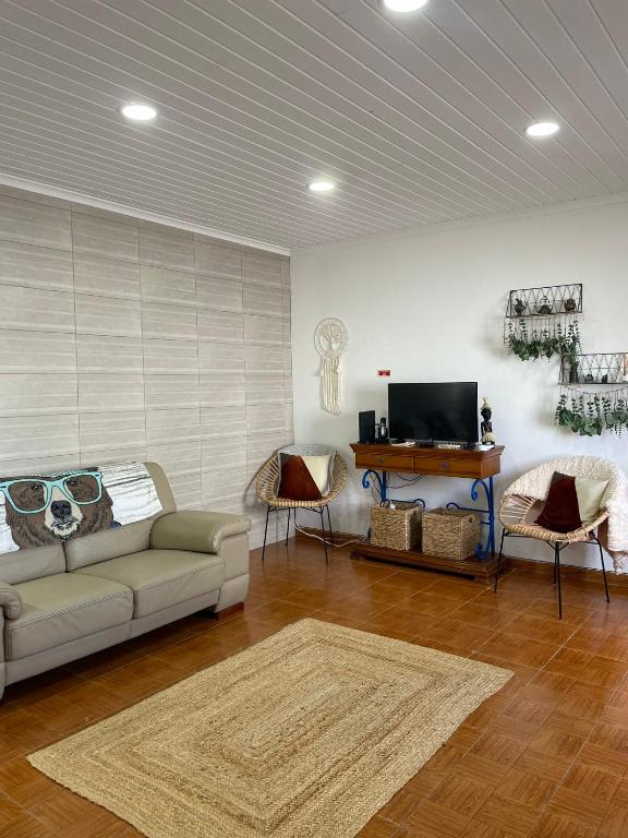 a living room with a couch and a table and a tv at House In The Valley in Algarvia