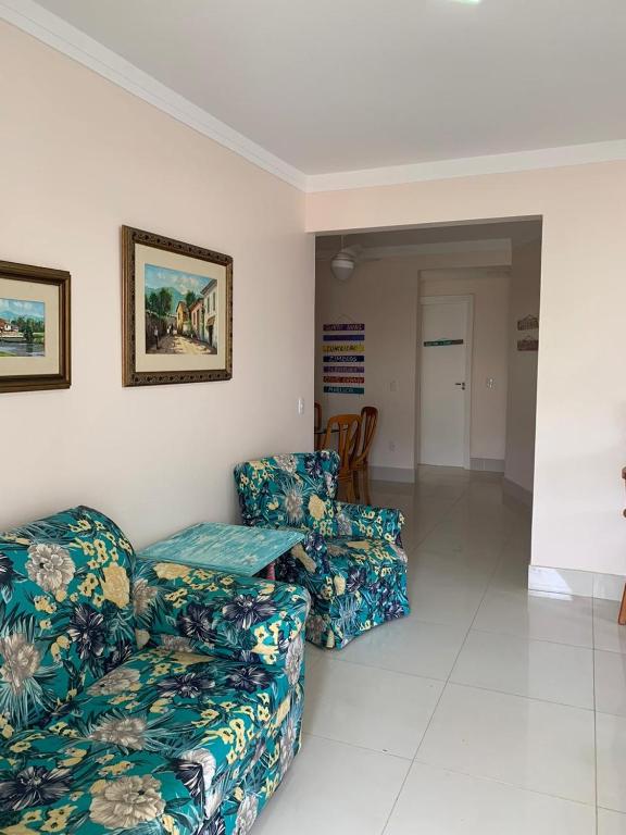 a living room with two couches and a table at Apartamento em Bombinhas - 120 metros da praia in Bombinhas