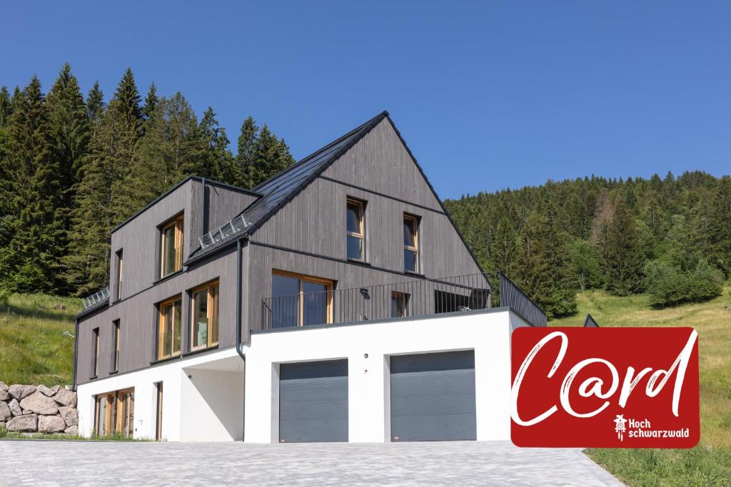 a large house with two garage doors and a sign at "Chalet H28" mit 4 Schlafzimmer in Todtnau-Muggenbrunn in Muggenbrunn