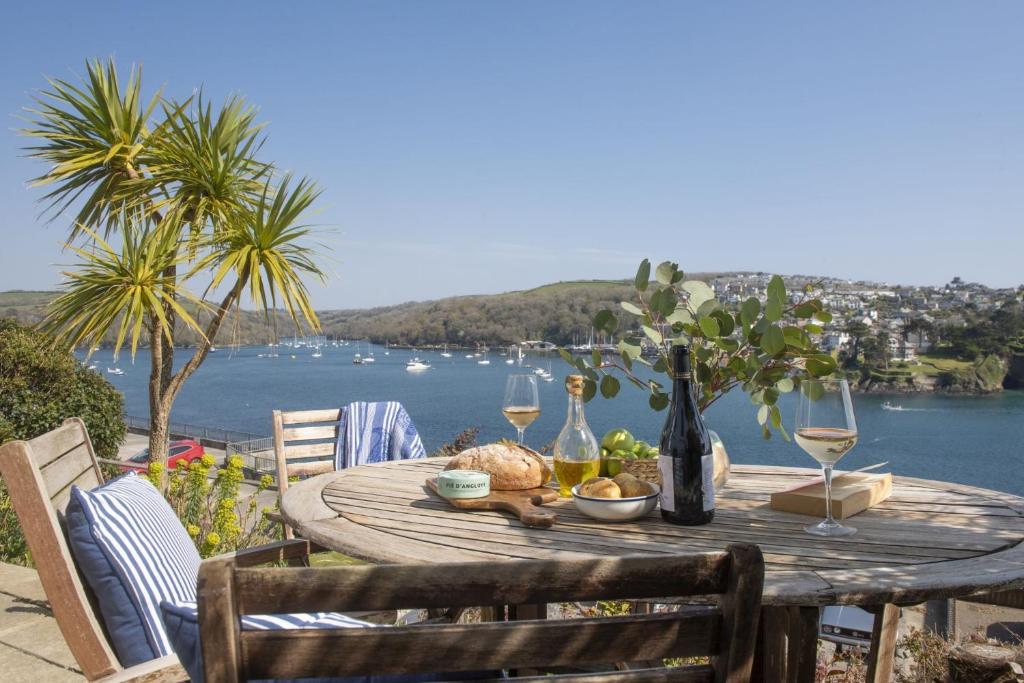 a table with wine glasses and a view of the water at Dolly's Plaice, Fowey in Fowey