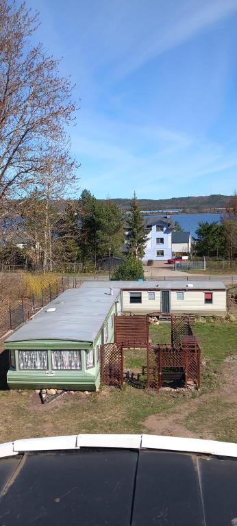 a green building with a roof on a field at Domki u Christiana in Nadole