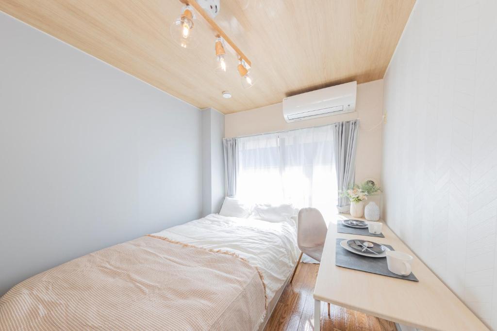 a small bedroom with a bed and a window at The Nest Koenji Cozy Stay near Station Easy Access to Shinjuku in Tokyo