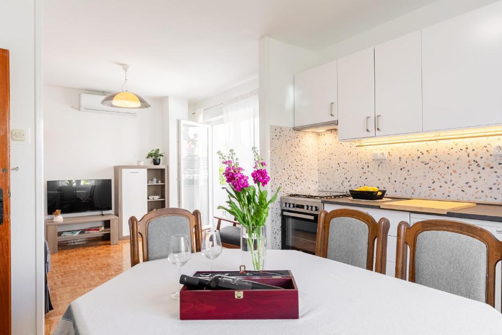 a kitchen with a table with a vase of flowers on it at Naša kuća in Vela Luka