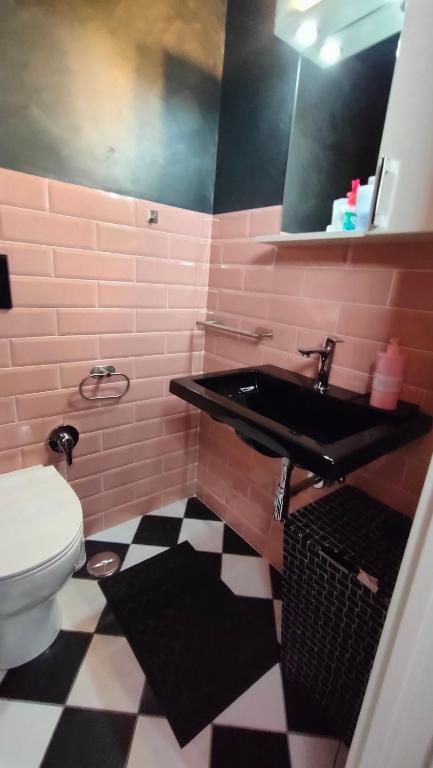 un bagno rosa con lavandino e servizi igienici di Secret Room Anagni ad Anagni