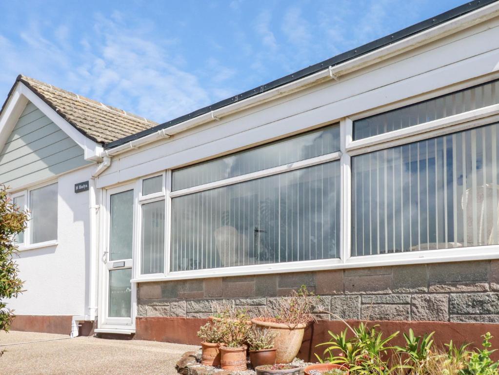 a white house with large windows at Harlyn in Mevagissey