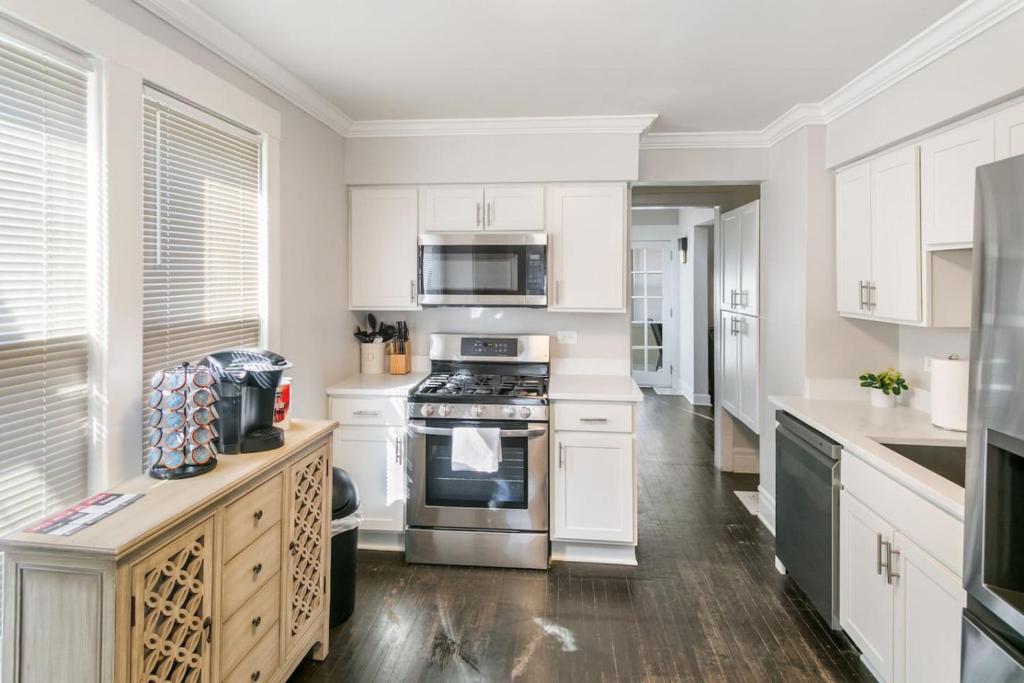 a kitchen with white cabinets and stainless steel appliances at Spacious Home in DT Libertyville Near Naval Base in Libertyville