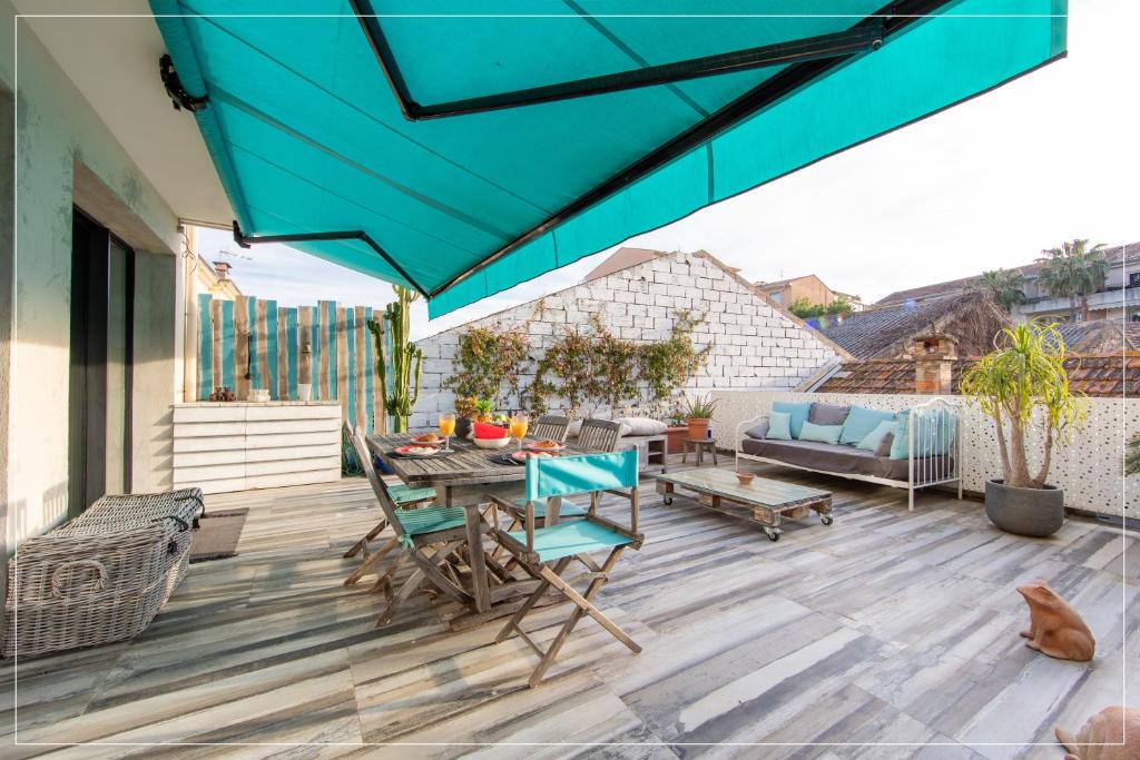 d'une terrasse avec des chaises, une table et un parasol bleu. dans l'établissement Design YourHostHelper, à Cannes