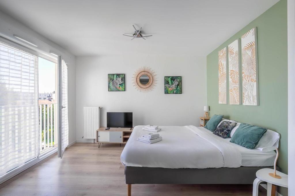 a bedroom with a large bed and a tv at Studio 30 m2 tout confort - RER à 3 min, accès Paris & Disneyland in Villiers-sur-Marne