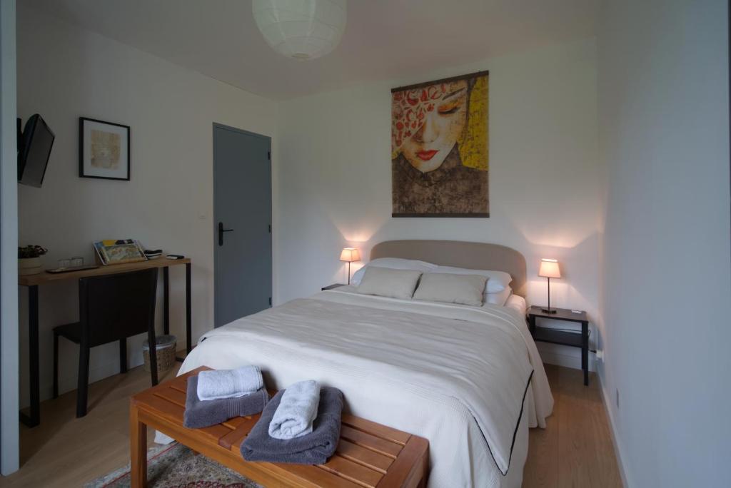 a bedroom with a large bed with towels on a table at Anna et Jean-Paul in LʼIsle-sur-la-Sorgue