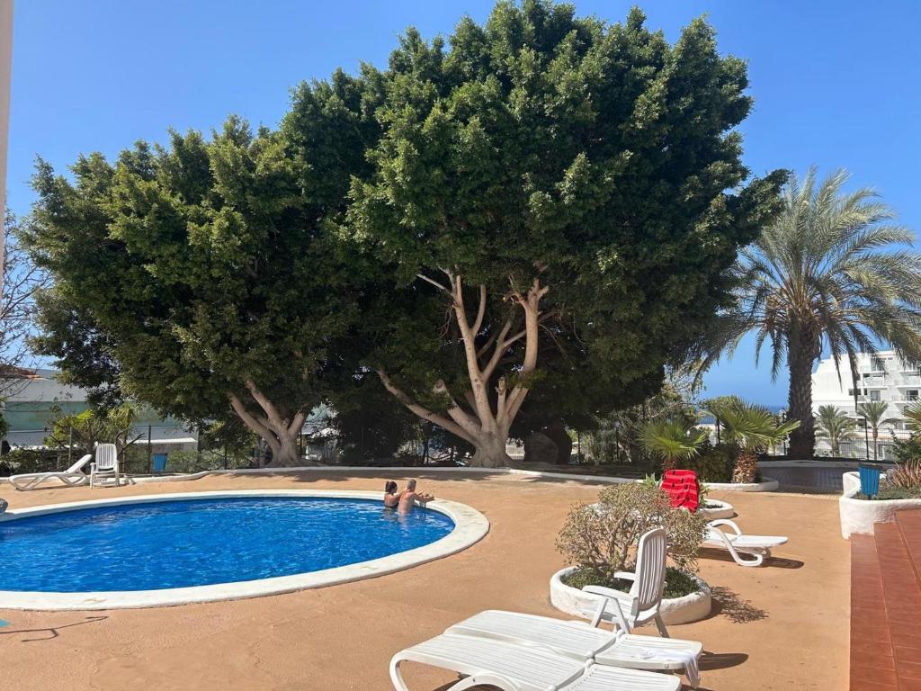 a swimming pool with two people in a resort at Mirador Paraiso in Adeje