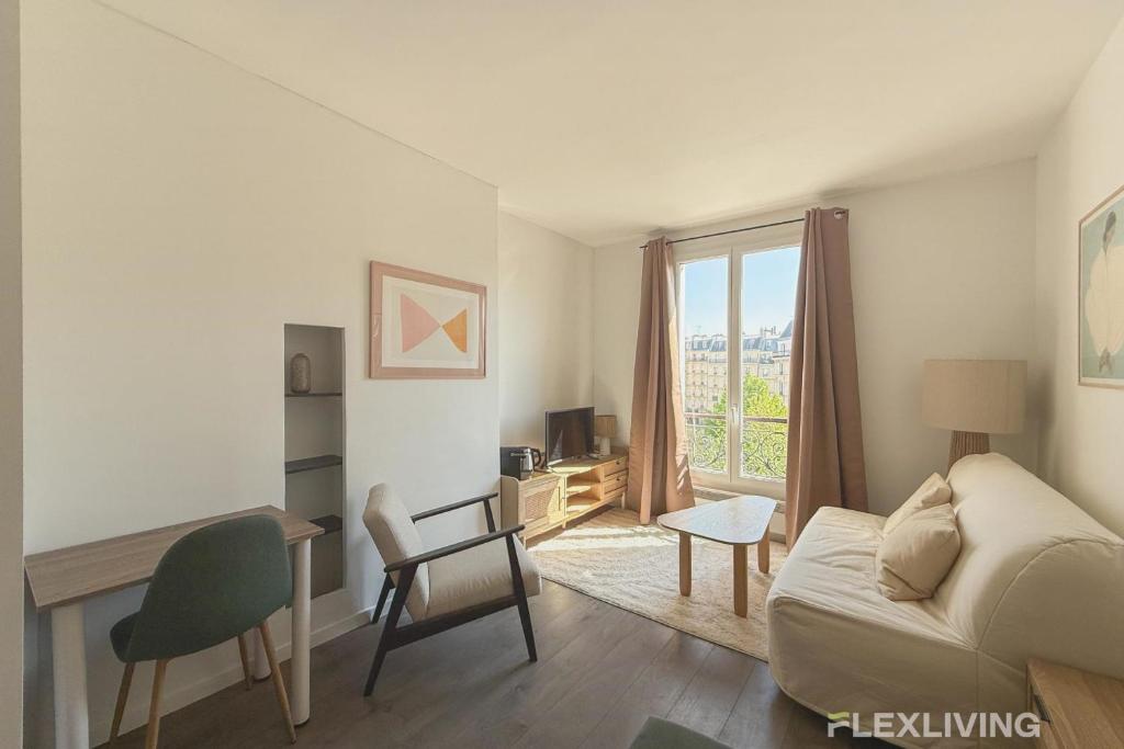 un salon avec un canapé, un bureau et une fenêtre dans l'établissement Flexliving - Studio - Patriarches, à Paris