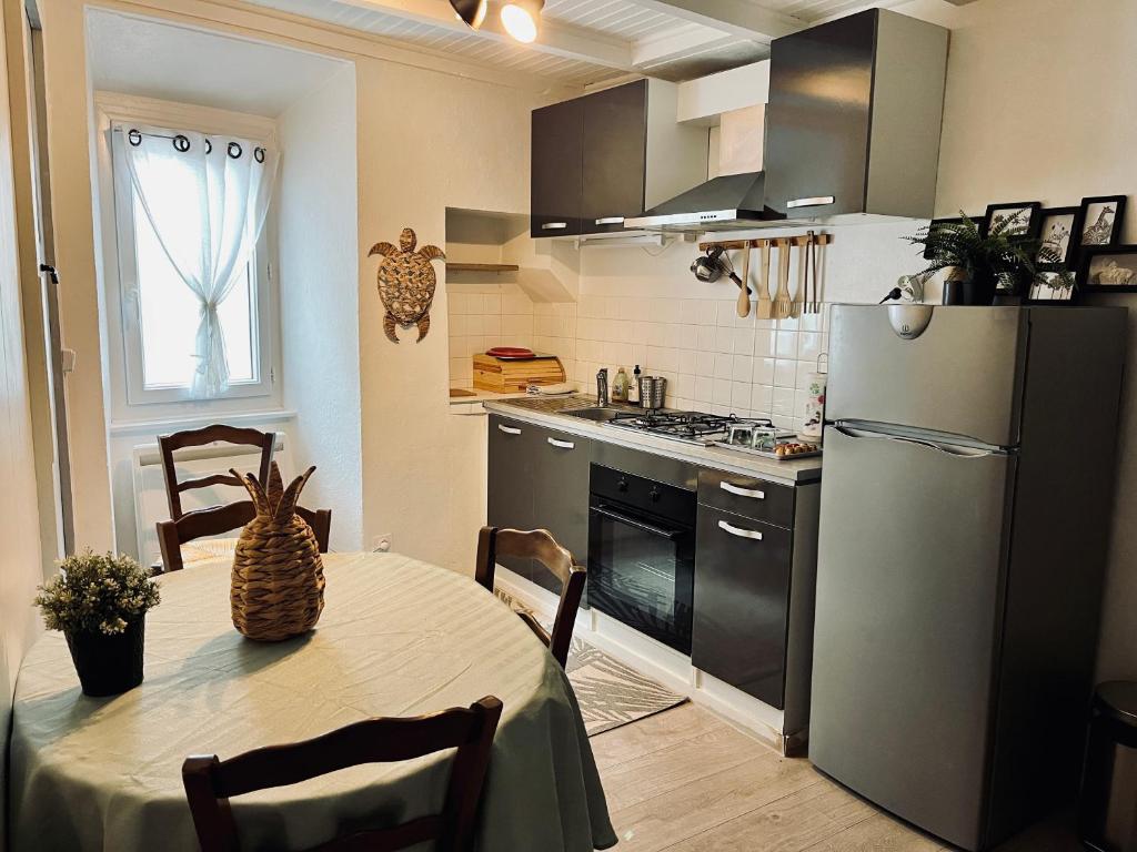 une cuisine avec une table et un réfrigérateur dans l'établissement Escapade provençale en gite esprit dortoir, à Saint-Nazaire-le-Désert